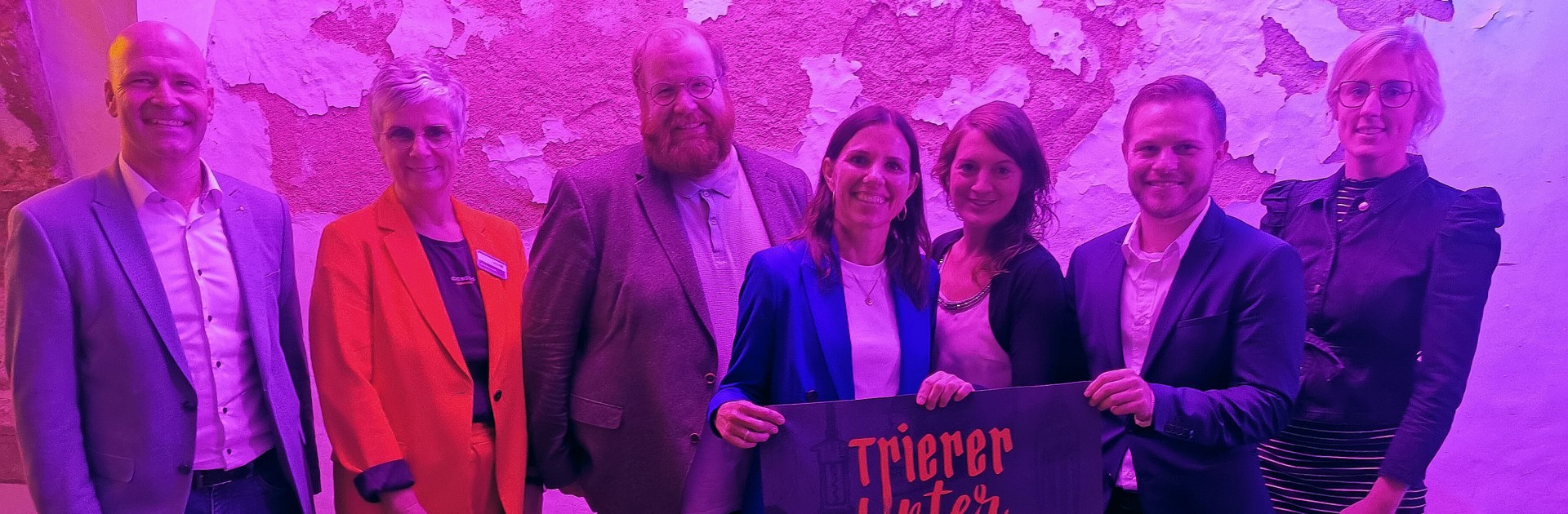 Das Gruppenfoto zeigt von links nach rechts: Carlo Schuff (Vorstandsstab der Sparkasse Trier),  Dorothé Richardt (Trier Tourismus und Marketing GmbH, TTM), Kulturdezernent Markus Nöhl, Elvira Classen (Leiterin des Amtes für Stadtkultur und Denkmalschutz), Unterwelten-Projektleiterin Alex Meusel (TTM), TTM-Geschäftsführer Yannick Jaeckert und Anna Adrian (Volksbank Trier)  - © Trier Tourismus und Marketing